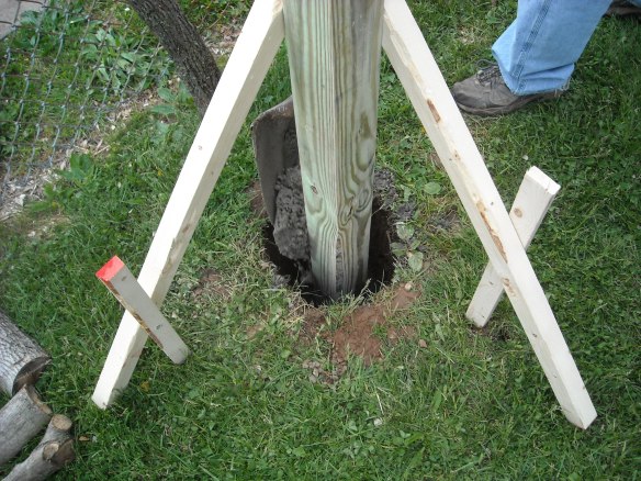Placing concrete around the vertical post.